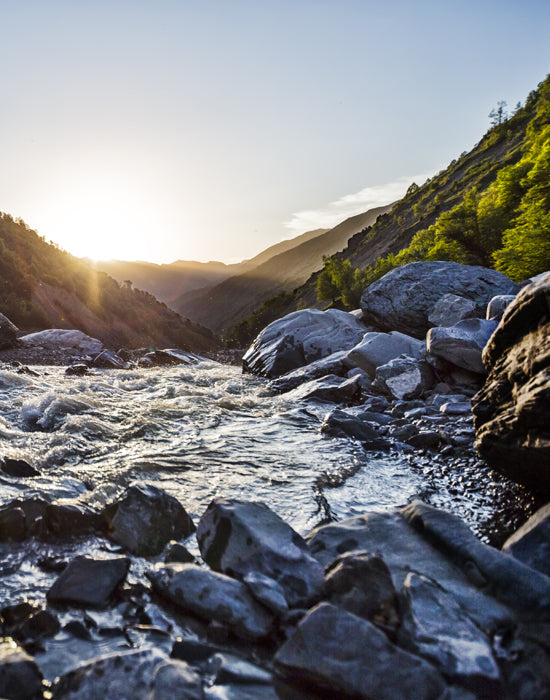 A beautiful sunset overshadowing a mountain stream